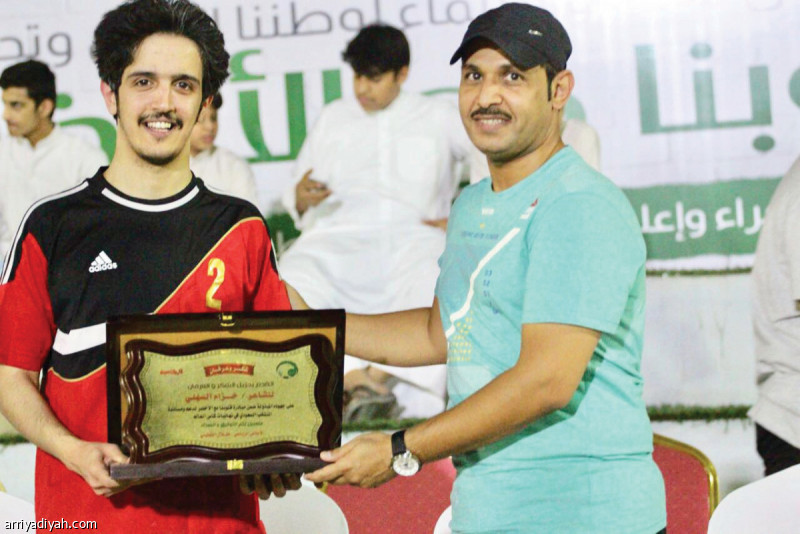 صورة التقطت أمس للزميل طلال القطيني يقدم درعاً تذكارية للشاعر خزام السهلي (المركز الإعلامي ـ اللجنة المنظمة)