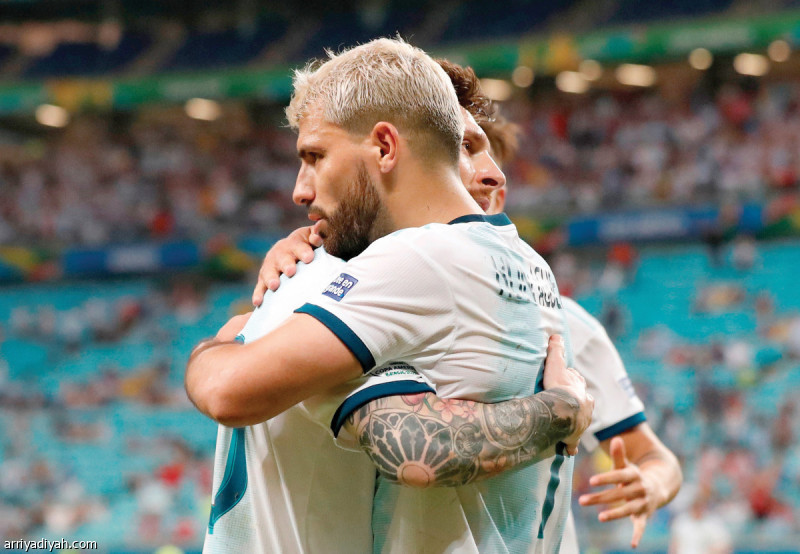 قاد الأرجنتينيان لاوتارو مارتينيز وسيرجيو أجويرو منتخب بلدهما إلى الدور الثاني من بطولة كوبا أمريكا بعد نجاحهما في تسجيل هدفين تحقق من خلالهما الفوز على قطر 2ـ0 في المواجهة التي جمعتهما ضمن المرحلة الأخيرة من الدور التمهيدي.. وقدم منتخب كولومبيا التأهل على طبق من ذهب للأرجنتينيين بعد حرمانه باراجواي من الصعود إثر فوزه عليه بهدف نظيف.. وفي الصورة التي التقطت أمس أجويرو يتبادل التهنئة مع ميسي بعد تسجيل الهدف الثاني للمنتخب الأرجنتيني (رويترز)