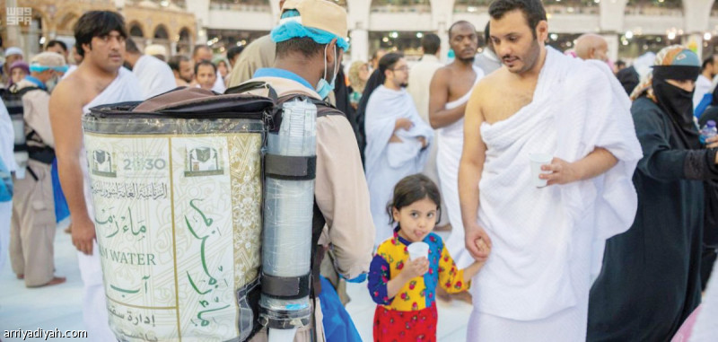 صورة التقطت أمس الأول لأحد المعتمرين مع طفلته يشربون ماء زمزم في الحرم المكي (واس)