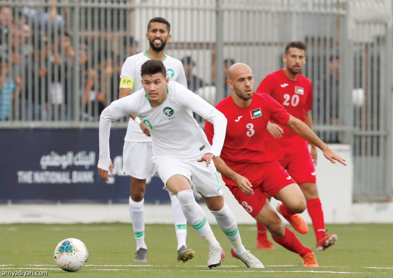 صورة التقطت أمس لعبد الله الحمدان مهاجم المنتخب السعودي الأول لكرة القدم ينطلق بالكرة وسط مطاردة محمد باسم لاعب وسط فلسطين.. ويظهر خلفهما سلمان الفرج قائد الأخضر (الفرنسية)