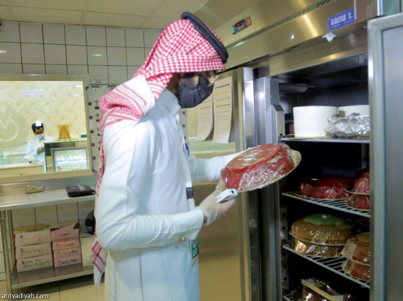 صورة التقطت أمس لمراقب من بلدية عنيزة في منطقة القصيم يعاين ثلاجة حلوى أثناء الجولات (واس)