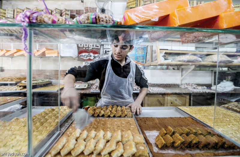 صورة التقطت أمس لخباز فلسطيني يعدّ حلويات عربية تقليدية لبيعها خلال الأسبوع الأخير من شهر رمضان المبارك استعدادًا لعيد الفطر في مخيم برج البراجنة للاجئين الفلسطينيين في بيروت العاصمة اللبنانية(رويترز)