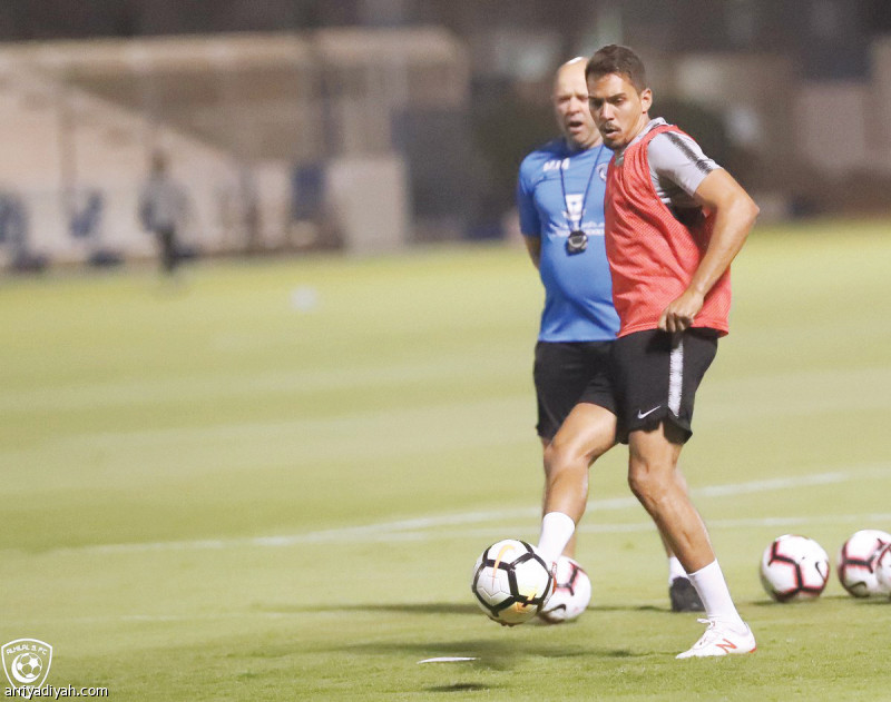صورة التقطت أمس للبرازيلي إدواردو يمرر الكرة خلال التدريبات.. ويبدو مساعد المدرب يراقبه