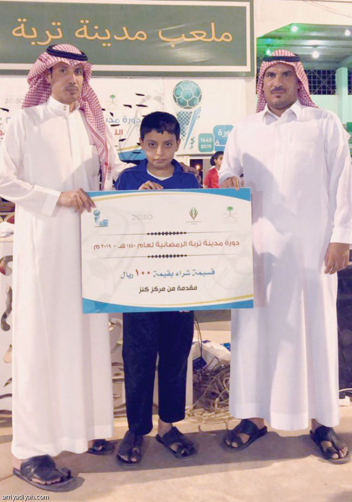 صورة التقطت أمس الأول لفريح الفضي ومثقال الخشمان عضوي اللجنة المنظمة يقدمان الجائزة لأحد المشجعين (الرياضية)