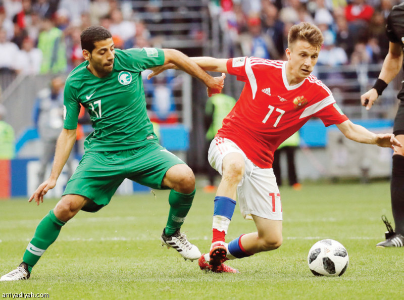 صورة التقطت لتيسير الجاسم لاعب المنتخب السعودي الأول لكرة القدم يحاول قطع الكرة من الروسي رومان زوبنين أثناء المباراة التي جمعت المنتخبين في افتتاح كأس العالم 2018 (أرشيفية)