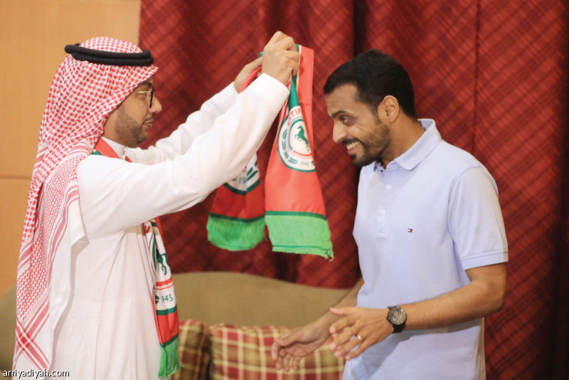صورة التقطت أمس لخالد الدبل رئيس الاتفاق يضع شعار ناديه على خالد العطوي المدرب السعودي بعد توقيع عقدٍ معه لقيادة الفريق الأول لكرة القدم في النادي لمدة موسم واحد تصوير: عيسى الدبيسي