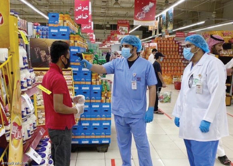 صورة التقطت أمس لمراقبي أمانة القصيم يقيسون الحرارة لدى العمالة داخل الأسواق التجارية (واس)