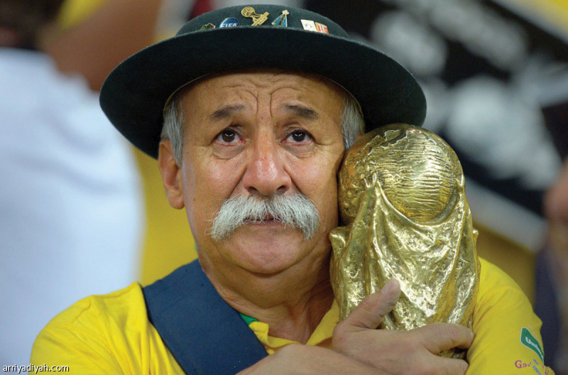 صورة التقطت لمشجع برازيلي يحمل نسخة تذكارية من كأس العالم (أرشيفية)