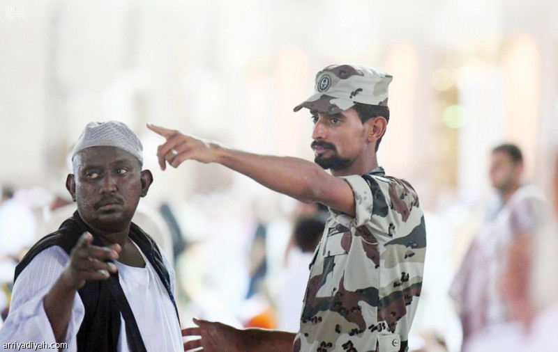 صورة التقطت أمس إلى أحد أفراد قوة الطوارئ يوجه زائراً للمسجد النبوي (واس)