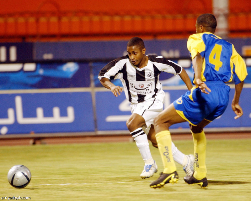 صورة التقطت لناجي مجرشي لاعب الشباب السابق ينطلق بالكرة.. ومحاولة من حمد الصقور لاعب النصر لإيقافه خلال المباراة التي جمعتهما عام 2004 (أرشيفية)