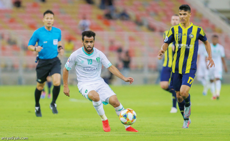 صورة التقطت أمس لعبد الفتاح عسيري لاعب الأهلي ينطلق بالكرة ويبدو الحكم الياباني تصوير: وهبان خبتي
