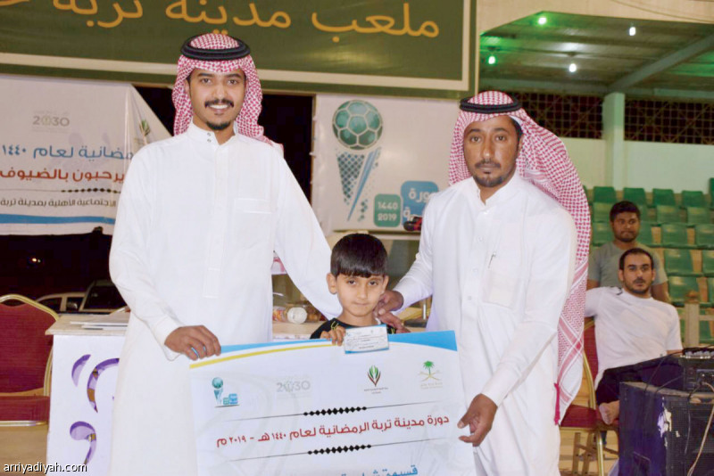 صورة التقطت أمس لعقيل الغربي عضو اللجنة المنظمة يسلم مشجعًا جائزته (الرياضية)