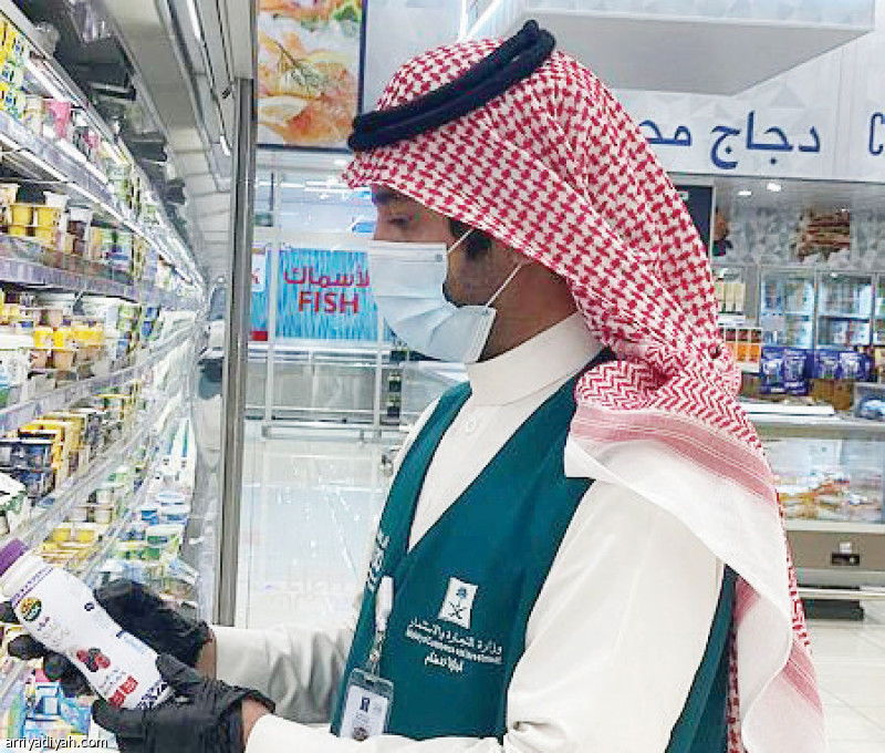 صورة التقطت أمس لمراقب من وزارة التجارة والاستثمار يعاين منتجات الألبان بمتجر في حائل (واس)
