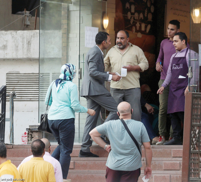 صورة التقطت أمس لمصريين يقفون متباعدين أمام متجر للحلوى في حي المعادي في القاهرة لشراء الكعك وباقي حلوى عيد الفطر (رويترز)